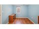 Bedroom features wood-look floors, blue walls, and a wood media cabinet at 3150 W Mexico Ave, Denver, CO 80219
