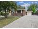 Charming brick home with a well-maintained front yard and a long driveway leading to a one-car garage at 3150 W Mexico Ave, Denver, CO 80219