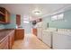 Basement kitchen includes appliances, wood cabinets, and tile floors at 3150 W Mexico Ave, Denver, CO 80219