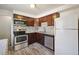 Updated kitchen features dark wood cabinets, stainless steel appliances, granite countertops, and modern backsplash at 3150 W Mexico Ave, Denver, CO 80219