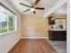 Cozy kitchenette area showcasing wood-paneled walls, hardwood flooring, a ceiling fan, and granite countertops at 3150 W Mexico Ave, Denver, CO 80219