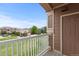 Balcony with a white railing offering views of lush green spaces and neighboring homes at 7440 S Blackhawk St # 207, Englewood, CO 80112