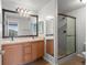 Bathroom featuring double sinks, a large mirror and a glass shower with custom tile at 7440 S Blackhawk St # 207, Englewood, CO 80112