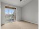Bright bedroom featuring a sliding glass door with a balcony view and neutral carpet at 7440 S Blackhawk St # 207, Englewood, CO 80112