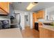 Fully-equipped kitchen featuring wood cabinetry, black appliances, and tile flooring, blending functionality with classic style at 7440 S Blackhawk St # 207, Englewood, CO 80112