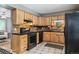 Functional kitchen with wooden cabinets, black countertops, and tile backsplash at 3530 W 95Th Ave, Westminster, CO 80031