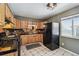 Well-lit kitchen with wooden cabinets, black appliances, and tile flooring at 3530 W 95Th Ave, Westminster, CO 80031