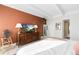 Main bedroom with terracotta feature wall and wood dresser at 7877 E Mississippi Ave # 604, Denver, CO 80247