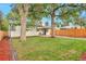 Serene backyard featuring mature trees, a well-manicured lawn, and a privacy fence at 1325 Dayton St, Aurora, CO 80010