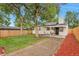 Serene backyard featuring a covered patio, a well-manicured lawn, and a privacy fence at 1325 Dayton St, Aurora, CO 80010