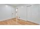 Bedroom featuring hardwood floors, white trim, closet, and an open door to another room at 1325 Dayton St, Aurora, CO 80010