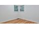 A bright bedroom showcasing hardwood floors, white walls and trim, and multiple windows at 1325 Dayton St, Aurora, CO 80010