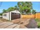 Detached garage featuring a large door, backyard fence, and new driveway at 1325 Dayton St, Aurora, CO 80010