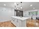 Bright kitchen featuring a white island with quartz countertop and modern pendant lighting at 1325 Dayton St, Aurora, CO 80010
