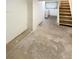 Unfinished basement with concrete floor, white walls, and stairs to main floor at 1920 Alton St, Aurora, CO 80010