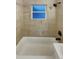 Bathroom with tile surround, tile floor, shower, and window at 1920 Alton St, Aurora, CO 80010