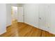 Bedroom featuring hardwood flooring, white trim, closet with white door, and view to bathroom at 1920 Alton St, Aurora, CO 80010