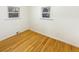 Bedroom featuring hardwood flooring, white trim, two windows, and neutral walls at 1920 Alton St, Aurora, CO 80010