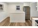 Eat-in kitchen featuring stainless refrigerator, white cabinetry, and breakfast bar with hardwood floors at 1920 Alton St, Aurora, CO 80010