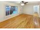 Bright living room features hardwood floors, a ceiling fan, and a large window overlooking the front yard at 1920 Alton St, Aurora, CO 80010