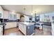 Bright kitchen featuring white cabinets, granite countertops, and an island at 3158 S Nepal Way, Aurora, CO 80013