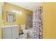 Bathroom showcasing a shower-tub combination, decorative shower curtain and flooring, sink and a large mirror at 4860 E 120Th Pl, Thornton, CO 80241