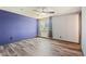 Bedroom with wood-look flooring, fan, a purple accent wall, and window for plenty of natural light at 4860 E 120Th Pl, Thornton, CO 80241