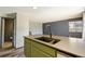 Close-up of a kitchen island with a modern sink and faucet, complemented by green cabinets and wood-look flooring at 4860 E 120Th Pl, Thornton, CO 80241