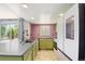 Bright kitchen featuring green cabinetry, stainless steel appliances, and a view to the outdoor scenery at 4860 E 120Th Pl, Thornton, CO 80241