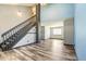 Open living space with staircase and featuring wood-look floors, and a view to the adjacent living area at 4860 E 120Th Pl, Thornton, CO 80241