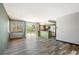 Bright living room featuring wood-look floors, natural light, and an open layout that leads to the kitchen at 4860 E 120Th Pl, Thornton, CO 80241