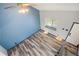 Bright living room features wood-look flooring, blue accent wall, fan, and a window for plenty of natural light at 4860 E 120Th Pl, Thornton, CO 80241