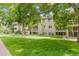 Exterior view of a condo building surrounded by lush trees and a green lawn at 20 S Boulder Cir # 2109, Boulder, CO 80303