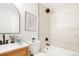 Bathroom featuring tile surround, modern fixtures, decorative mirror, and sleek toilet at 13202 Olmsted Pl, Denver, CO 80239