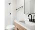 Stylish bathroom boasts modern fixtures, a wood vanity, and a sleek mirror at 13202 Olmsted Pl, Denver, CO 80239