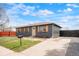 Charming home with gray brick, wood shutters, a manicured lawn, and a concrete driveway at 13202 Olmsted Pl, Denver, CO 80239