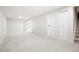 Spacious living room with neutral carpet, white walls, and access to the upper level stairs at 13202 Olmsted Pl, Denver, CO 80239