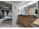 Bright bathroom with double vanity, granite countertop, modern lighting, and access to the primary bedroom at 2229 Blake St # 505, Denver, CO 80205