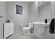Powder room featuring a white pedestal sink, gray tile floors, modern fixtures, and decorative artwork at 2229 Blake St # 505, Denver, CO 80205