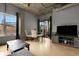 Bright living room with a dining area, large windows, entertainment center, and exposed ductwork at 2229 Blake St # 505, Denver, CO 80205