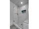 Modern bathroom shower with white marble tiles, glass door, and built-in niche for toiletries at 2229 Blake St # 505, Denver, CO 80205