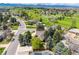 Picturesque aerial view showcasing homes neighboring a well-manicured golf course with mountain views at 5365 W Princeton Dr, Denver, CO 80235