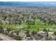 Extensive aerial perspective of a neighborhood overlooking a golf course with water features and mountain views at 5365 W Princeton Dr, Denver, CO 80235