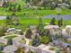 Stunning aerial view of homes nestled in a lush, green golf course community with lake at 5365 W Princeton Dr, Denver, CO 80235