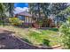 Spacious backyard with mature trees, a wooden staircase and brick accents, perfect for outdoor enjoyment at 5365 W Princeton Dr, Denver, CO 80235
