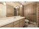 Bathroom with a vanity, marble countertop, patterned wallpaper, and a shower at 5365 W Princeton Dr, Denver, CO 80235