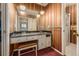 Bathroom vanity with black marble countertop, white cabinets, stool, and unique pendant lights at 5365 W Princeton Dr, Denver, CO 80235