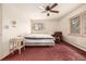Cozy bedroom featuring a bed, side table, sitting chair, and windows with shutters at 5365 W Princeton Dr, Denver, CO 80235