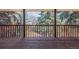 Outdoor deck with wood railing showcasing a view of lush green trees and backyard at 5365 W Princeton Dr, Denver, CO 80235