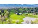 Scenic view of the golf course with lush green fairways and water features, set against a backdrop of mountains at 5365 W Princeton Dr, Denver, CO 80235